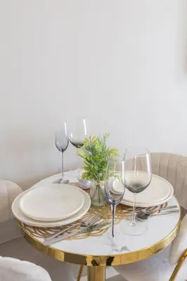 a table with plates and wine glasses on it at GreenPark Home A chic retreat and peaceful home in Boksburg