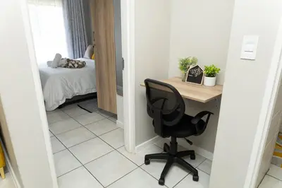 a desk and a chair in a room with a bed at GreenPark Home A chic retreat and peaceful home in Boksburg