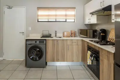 a kitchen with a washing machine in the middle at GreenPark Home A chic retreat and peaceful home in Boksburg
