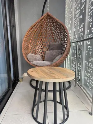 a hanging rattan chair and a table in a room at Elegant AirConditioned Neria at Ellipse Waterfall in Midrand