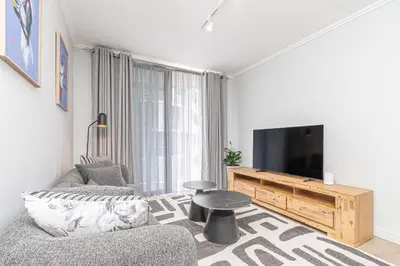 a living room with a couch and a tv at Elegant AirConditioned Neria at Ellipse Waterfall in Midrand