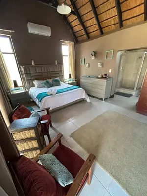 a bedroom with a bed and a couch in it at Dorpsrus in Bela-Bela