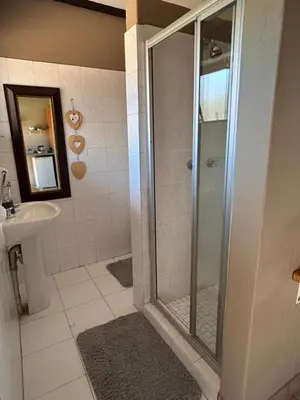 a bathroom with a shower and a sink at Dorpsrus in Bela-Bela