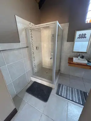 a bathroom with a shower and a sink at Dorpsrus in Bela-Bela