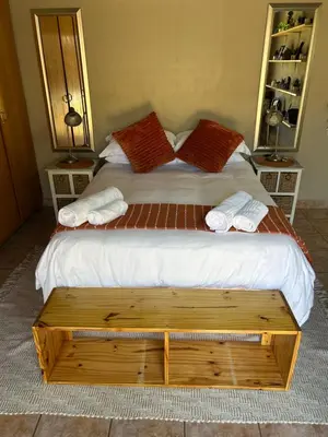 a bedroom with a large bed with two pillows at Dorpsrus in Bela-Bela