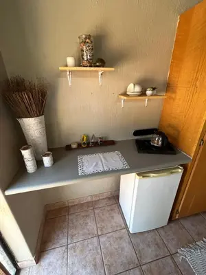 a kitchen with a counter and a small refrigerator at Dorpsrus in Bela-Bela