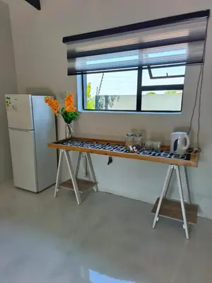 a kitchen with a table and a refrigerator and a window at the Host at Bingos House in Thohoyandou