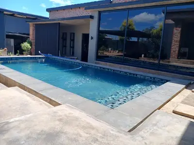 a swimming pool in front of a house at the Host at Bingos House in Thohoyandou