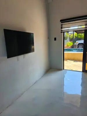 a living room with a flat screen tv on a wall at the Host at Bingos House in Thohoyandou
