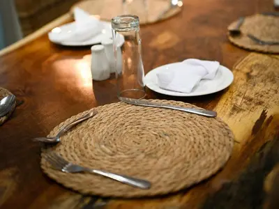a wooden table with plates and utensils on it at The Roaming Goat Guesthouse in Toekoms