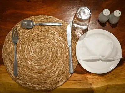 a wooden table with utensils and a plate and spoon at The Roaming Goat Guesthouse in Toekoms