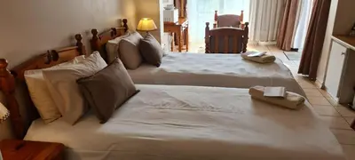 a bedroom with two beds with white sheets at Bloemhoek Guest House in Centurion