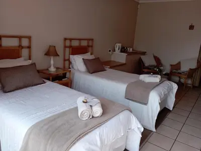 a hotel room with two beds with towels on them at Bloemhoek Guest House in Centurion