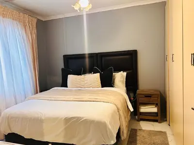 a bedroom with a large bed with a black headboard at 33OnPangolin B&B in Nelspruit