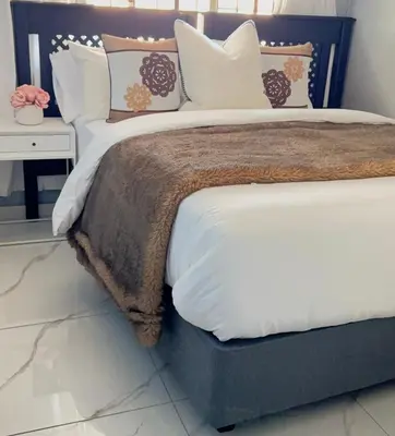 a bedroom with a large bed with pillows at 33OnPangolin B&B in Nelspruit