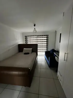 a living room with a couch and a window at Sunset Rest Guesthouse in Secunda