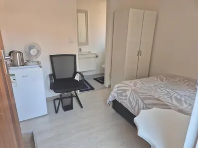 a bedroom with a bed and a chair in it at TALOEM Private Room in Pretoria