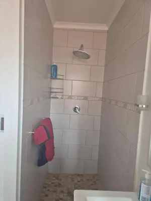 a bathroom with a shower with a red towel at TALOEM Private Room in Pretoria