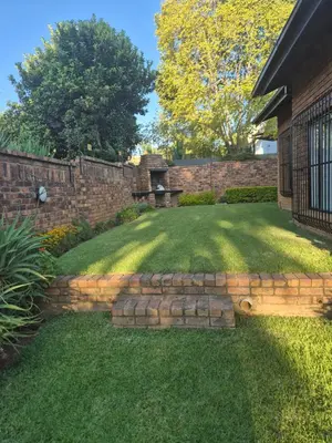 a backyard with a retaining wall and a stone walkway at TALOEM Private Room in Pretoria