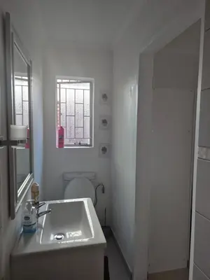 a white bathroom with a sink and a toilet at TALOEM Private Room in Pretoria