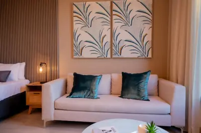 a living room with a couch in a hotel room at 129 at Menlyn Maine in Pretoria