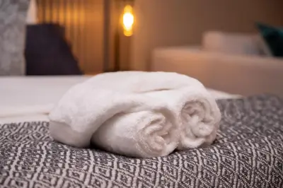 a white towel sitting on top of a bed at 129 at Menlyn Maine in Pretoria