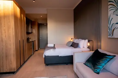 a hotel room with a bed and a couch at 129 at Menlyn Maine in Pretoria