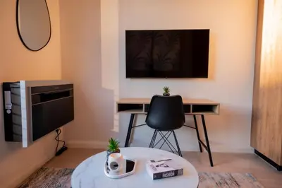 a living room with a desk and a tv at 129 at Menlyn Maine in Pretoria