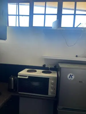 a kitchen with a stove and some windows at Kwa George in Pretoria