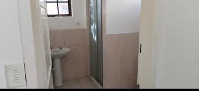 a bathroom with a shower and a sink at Kwa George in Pretoria
