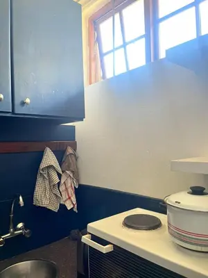 a small kitchen with a stove and a sink at Kwa George in Pretoria