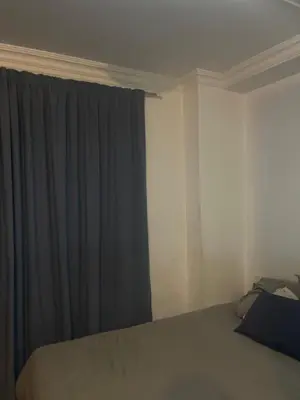 a bedroom with a bed and a window with curtains at Kwa George in Pretoria