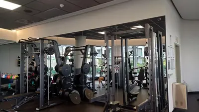 a gym with a bunch of machines in a room at Golden Sunrise Suite at The Ellipse Waterfall in Midrand