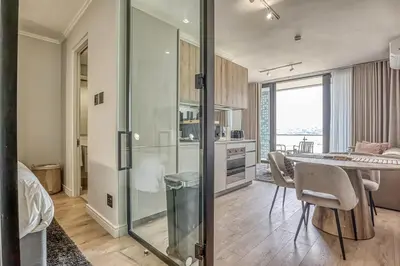 a kitchen and dining room with a table and chairs at Golden Sunrise Suite at The Ellipse Waterfall in Midrand