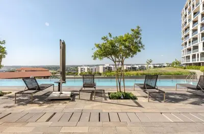 a group of chairs sitting next to a pool at Golden Sunrise Suite at The Ellipse Waterfall in Midrand
