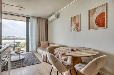 a living room with a table and chairs and a couch at Golden Sunrise Suite at The Ellipse Waterfall in Midrand