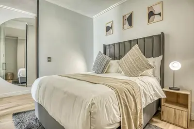 a bedroom with a large bed with a large mirror at Golden Sunrise Suite at The Ellipse Waterfall in Midrand