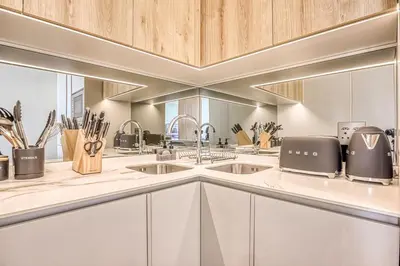 a kitchen with white cabinets and stainless steel appliances at Ellipse Waterfall Luxe Retreat in Midrand