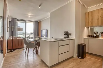 a kitchen with a counter and a table in a room at Ellipse Waterfall Luxe Retreat in Midrand