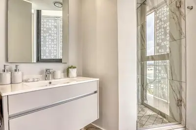a bathroom with a sink and a shower at Ellipse Waterfall Luxe Retreat in Midrand