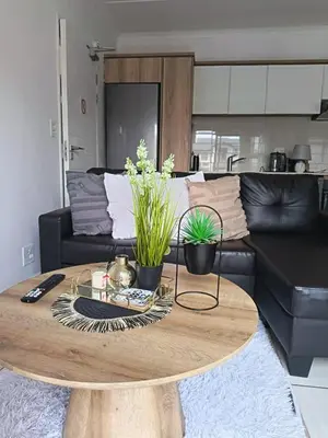 a coffee table in a living room with a couch at The Blyde Cozy 1-Bedroom in Pretoria