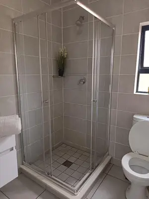 a shower with a glass door in a bathroom at The Blyde Cozy 1-Bedroom in Pretoria