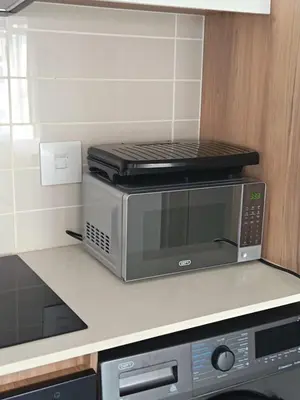 a microwave oven sitting on top of a kitchen counter at The Blyde Cozy 1-Bedroom in Pretoria