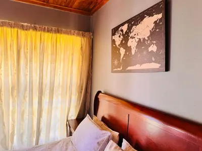a bedroom with a bed and a picture on the wall at Bophelong Guest House in Witbank