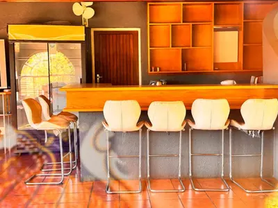 a bar with white bar stools in a kitchen at Bophelong Guest House in Witbank