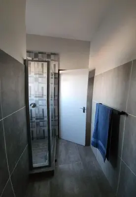 a bathroom with a mirror and a white door at One at Corridor in Witbank