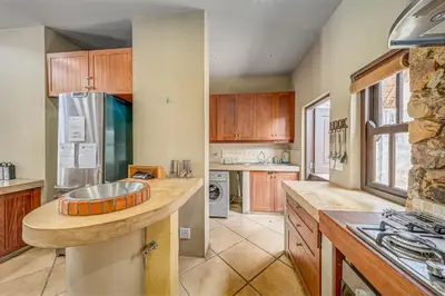 a large kitchen with wooden cabinets and a counter top at Bushveld Haven - Golf, Spa & Safari Lodge Stay in Warmbaths