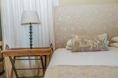 a bedroom with a bed and a lamp and a chair at Bushveld Haven - Golf, Spa & Safari Lodge Stay in Warmbaths