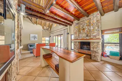a kitchen with a counter and a fireplace in a room at Bushveld Haven - Golf, Spa & Safari Lodge Stay in Warmbaths