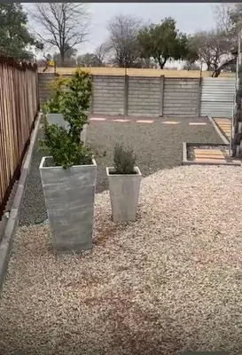 two potted plants sitting on top of gravel at 26 Rubens apartments in Secunda